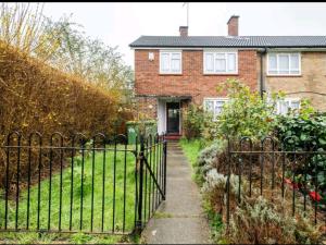 a fence in front of a brick house at London Stratford Holiday Home in London