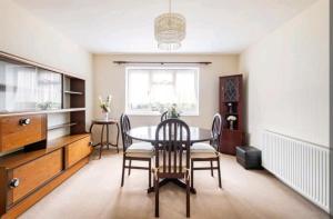 a dining room with a table and chairs at London Stratford Holiday Home in London