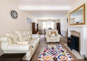 ロンドンにあるLondon Stratford Holiday Homeのリビングルーム(白い椅子2脚、暖炉付)