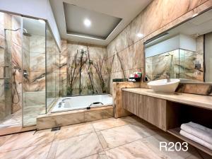 a bathroom with a tub and a sink at Cigar Motel in Tainan