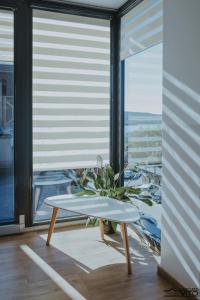 una mesa frente a una gran ventana con una planta en Kompleks Tawerna Vito - Apartamenty Vito, en Czorsztyn