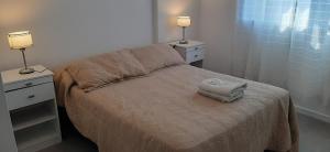1 dormitorio con 1 cama con 2 mesitas de noche y 2 lámparas en Departamento Solares - San Martin en Bahía Blanca