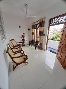 szereg krzeseł siedzących w pokoju w obiekcie Jasmine Apartments w Negombo