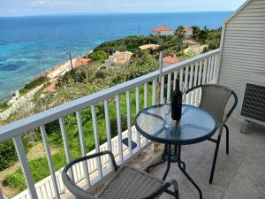 un tavolo e sedie su un balcone con vista sull'oceano di FIORE ROOMS ad Akrotiri