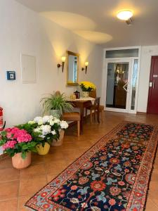 a living room with a rug and a table with flowers at Hotel Wittgensteiner Hof in Bad Laasphe