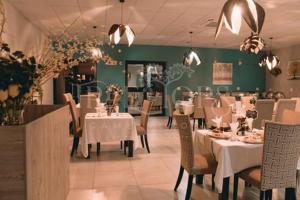 Magomba的住宿－Tree Tops Game Resort，餐厅配有桌椅和白色的桌布