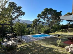 una piscina en un patio con una mesa de picnic en Casa y cabaña vista a las sierras, en Villa Giardino