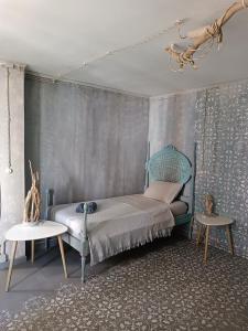 a bedroom with a bed with a chair and a table at Avó da Rosa 1 in Ribeira Quente