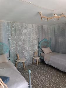 a bedroom with two beds and two tables at Avó da Rosa 1 in Ribeira Quente +3 photos