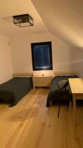 Życiny的住宿－Zielone Drzwi，一间卧室设有两张床、一张桌子和一个窗口。