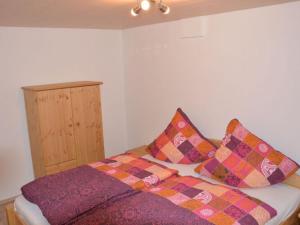 una cama con almohadas coloridas encima en Ferienhof Schönmetzler, en Altusried