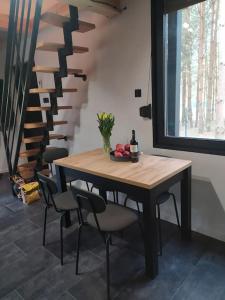 a dining room table with chairs and a staircase at Zielone Drzwi in Życiny +14 photos