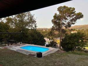 Una piscina en un patio con una mesa y árboles en Casa y cabaña vista a las sierras, en Villa Giardino