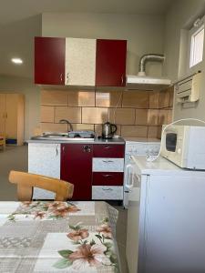 a kitchen with red cabinets and a table with a microwave at Grande in Mediaş