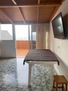 a room with a table with a tv on the wall at Apartment with sea view! Mesa del Mar 120 in Santa Cruz de Tenerife