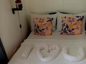 two towels in the shape of a heart on a bed at Strandhaus Condotel in Moalboal