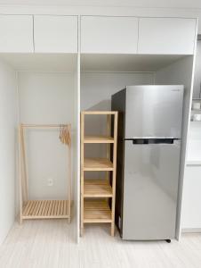 a kitchen with a refrigerator and a book shelf at Ari Home - Free parking, 15mins to Cheonan Station, 20mins Sejong Emerson, 25mins to Woojeong Hills in Cheonan