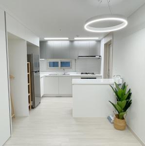 a kitchen with white cabinets and a white counter top at Ari Home - Free parking, 15mins to Cheonan Station, 20mins Sejong Emerson, 25mins to Woojeong Hills in Cheonan