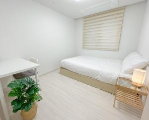 a small bedroom with a bed and a desk at Ari Home - Free parking, 15mins to Cheonan Station, 20mins Sejong Emerson, 25mins to Woojeong Hills in Cheonan