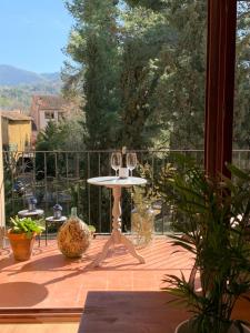 een balkon met een tafel met wijnglazen erop bij Com a casa in Falset