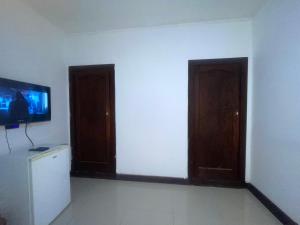 a room with two doors and a tv on a wall at Khaya Mnandi Leisure Suites in Pretoria