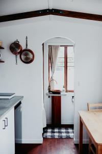 a kitchen with white walls and a table and a window at Cozy & Thoughtful Tiny Home in Kallangur