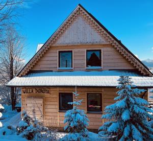 a log cabin in the snow with a sign on it at Villa Dorota in Zakopane