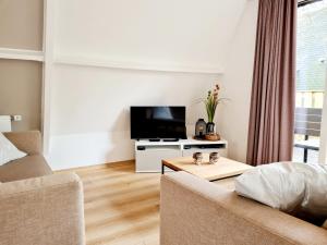 a living room with a couch and a flat screen tv at Chalet d Ooghe in Durbuy