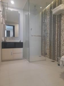 a bathroom with a shower and a sink and a mirror at Happy Home in Nha Trang