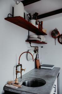 a kitchen counter with a sink and a shelf at Cozy & Thoughtful Tiny Home in Kallangur