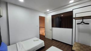 a white room with two beds and a mirror at My Misto Homestay, Riverson Soho in Kota Kinabalu