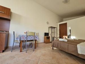 マツァーラ・デル・ヴァッロにあるSicilia Bellaのテーブル、椅子、ベッドが備わる客室です。