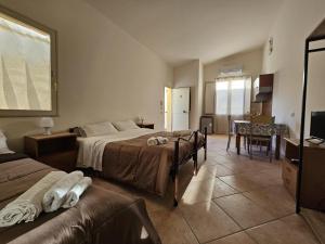 a hotel room with three beds and a dining room at Sicilia Bella in Mazara del Vallo