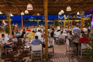 un grupo de personas sentadas en mesas en un restaurante en Mamaia Summerland Sunwaves en Mamaia