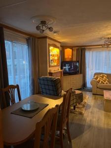 a living room with a dining room table and a television at Luxury modern caravan Seton Sands in Port Seton