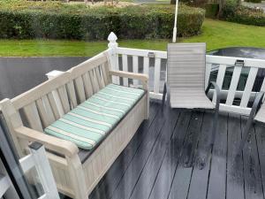 a bench and a chair on a deck at Luxury modern caravan Seton Sands in Port Seton