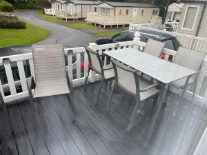 a table and chairs sitting on a deck at Luxury modern caravan Seton Sands in Port Seton