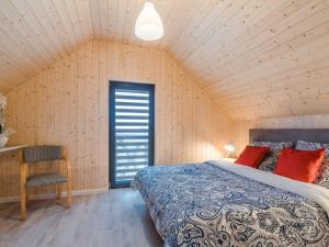 a bedroom with a bed and a chair in a room at Domki Kasjopeja in Władysławowo