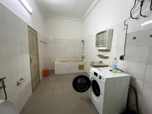 a bathroom with a washing machine and a sink at Appartement spacieux bien situé in Cotonou