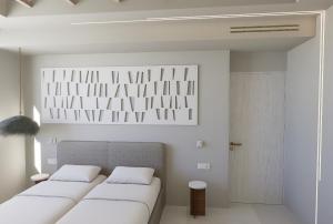 2 Betten in einem Zimmer mit weißen Wänden in der Unterkunft Haraki Village in Charaki