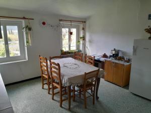 cocina con mesa, sillas y nevera en hOMe-Shanti Galamus en Saint-Paul-de-Fenouillet