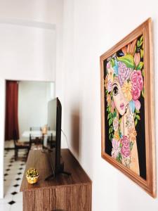 una pintura de una mujer en una pared junto a una mesa en Departamentos PLENO CENTRO en Tupungato