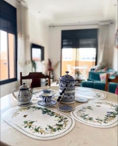 a table with plates and tea sets on it at Nice apartment in the city center in Marrakech