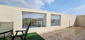 a balcony with a table and chairs and a window at شذا المصيف لبيوت العطلات in Al Shafa