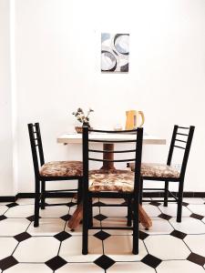 een eettafel en stoelen met een zwart-witte vloer bij Habitaciones PLENO CENTRO in Tupungato