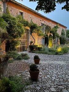 a brick building with potted plants in front of it at LA CLE d'ESCAMPS in Escamps