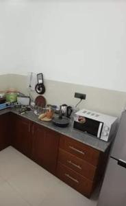 kuchnia z kuchenką i kuchenką mikrofalową w obiekcie Jasmine Apartments w Negombo