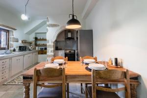 a large kitchen with a wooden table and chairs at To Patriko in Kournás