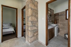 a bathroom with a stone wall next to a sink at To Patriko in Kournás