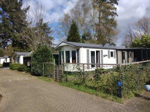 a white house with a fence in front of it at Chalet Relax in Putten